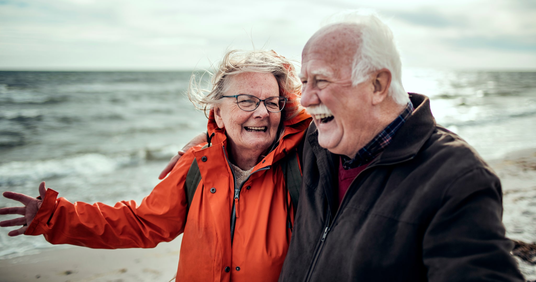 Vanha pariskunta iloisena rannalla